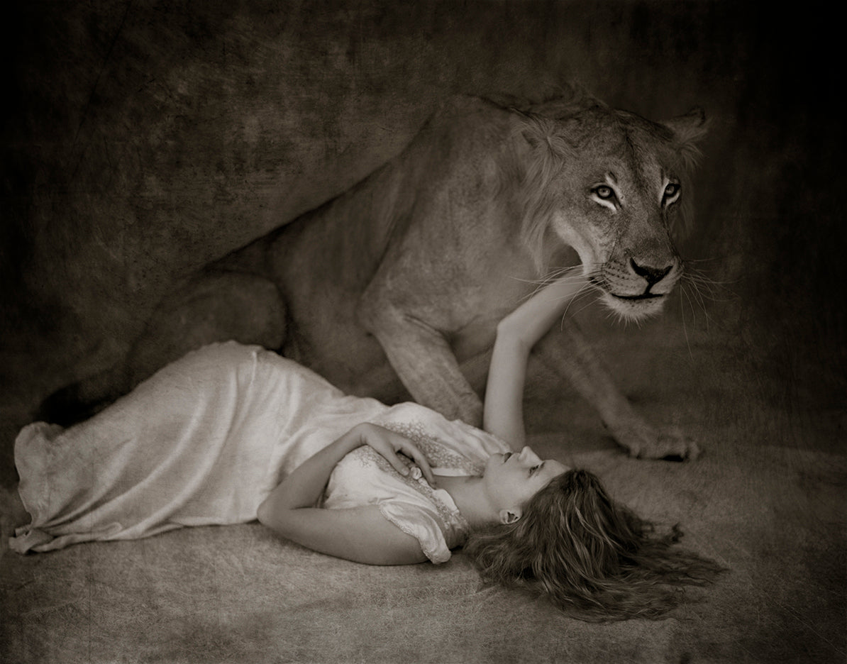 girl laying below a wild lion in a loving embrace