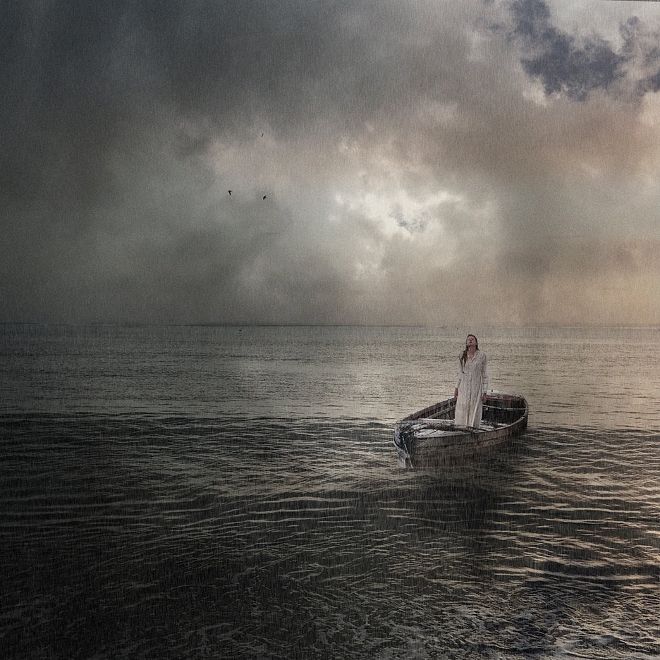 A ethereal image of a person standing in a boat on calm waters under a cloudy sky with a cross superimposed over the person's figure.