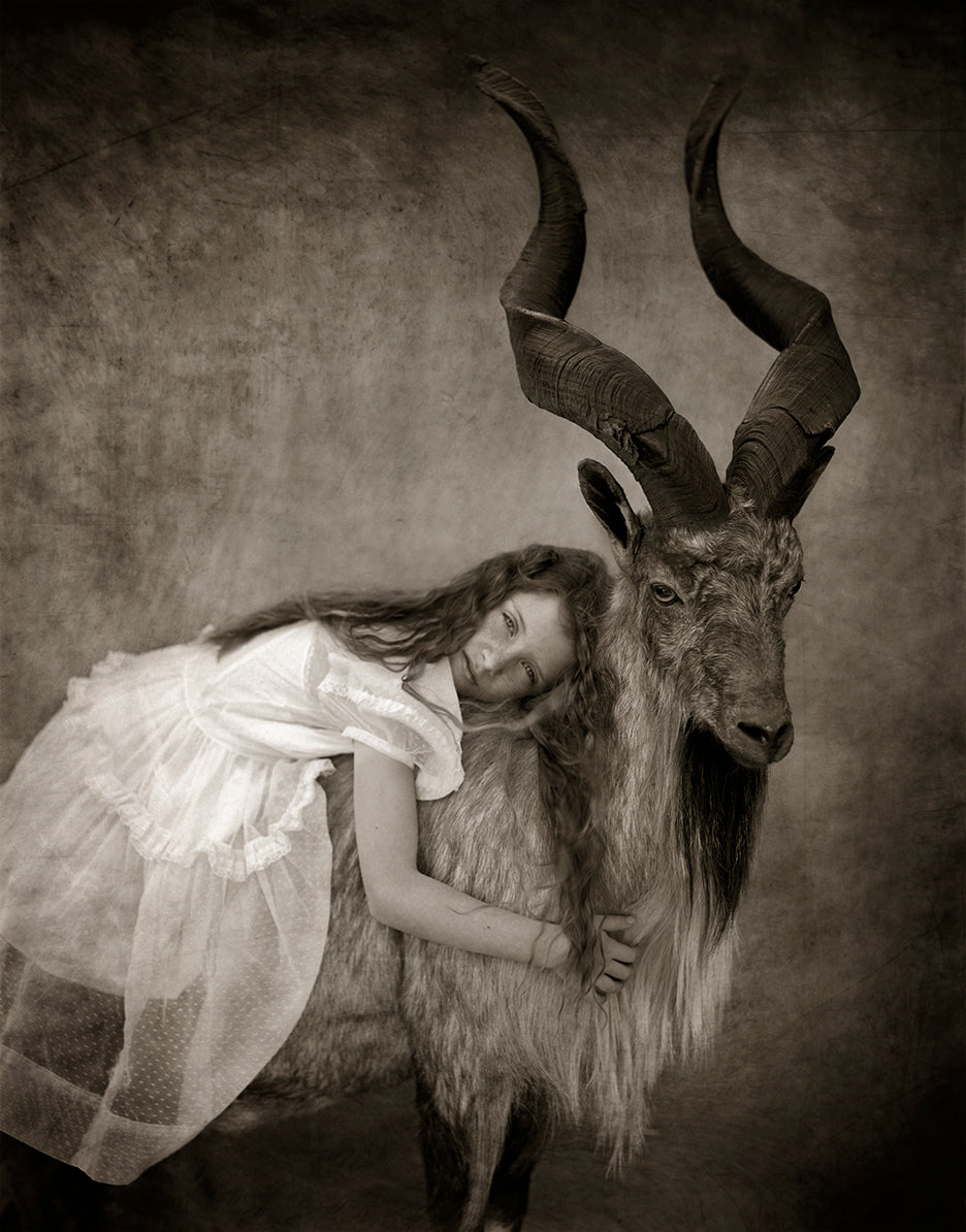 Girl laying on an Aex Ram in sepia tone fine art