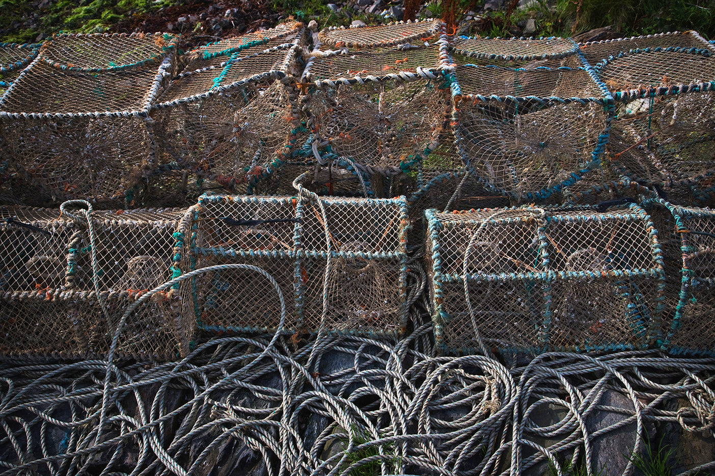 A stack of traditional-style fishing nets with green trim, laid out on a surface, possibly drying or displayed.