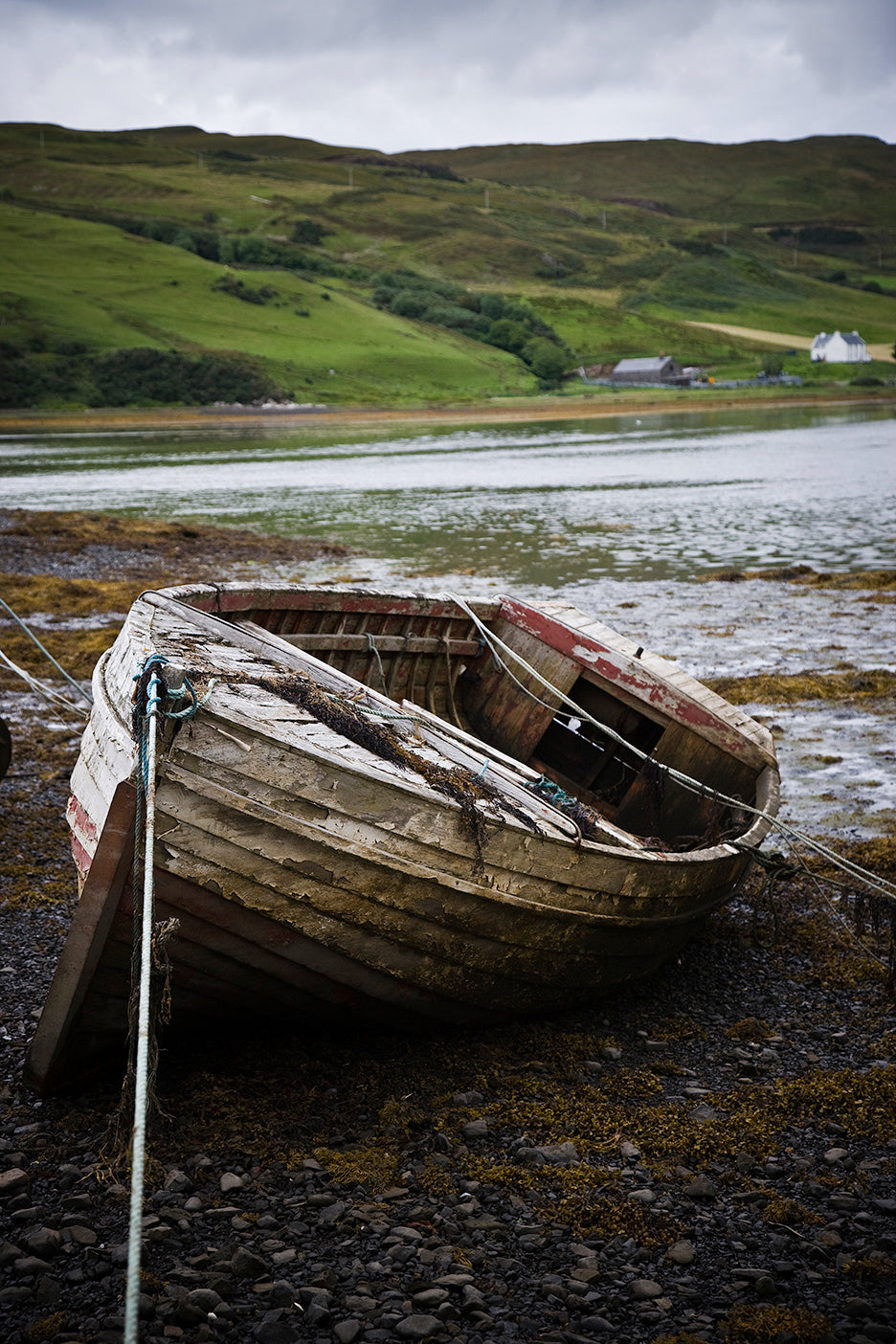 beahed boat with green hilss of Scotland
