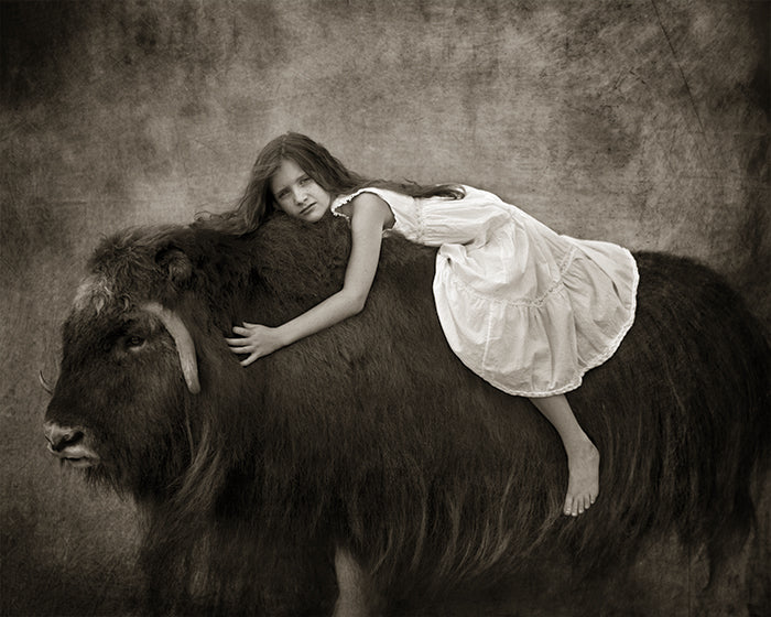 girl riding on buffao in sepia