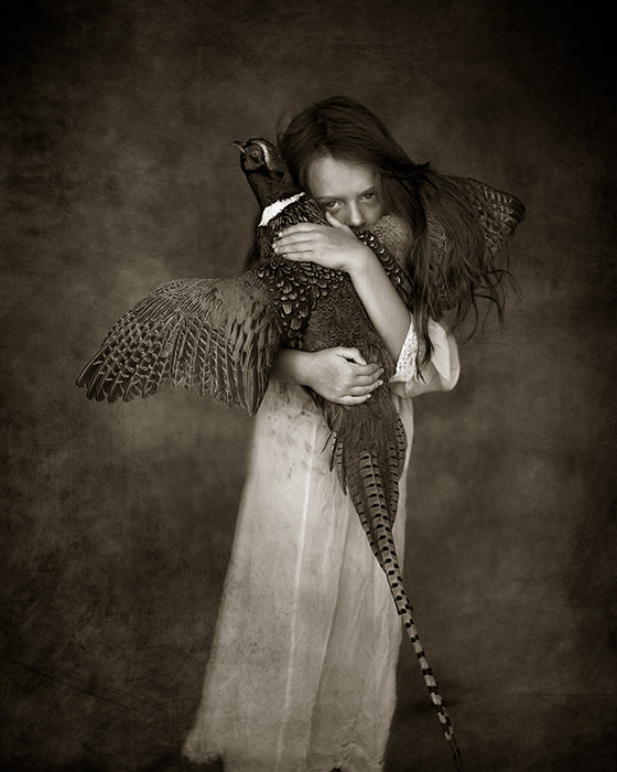 girl holding onto a pheasant