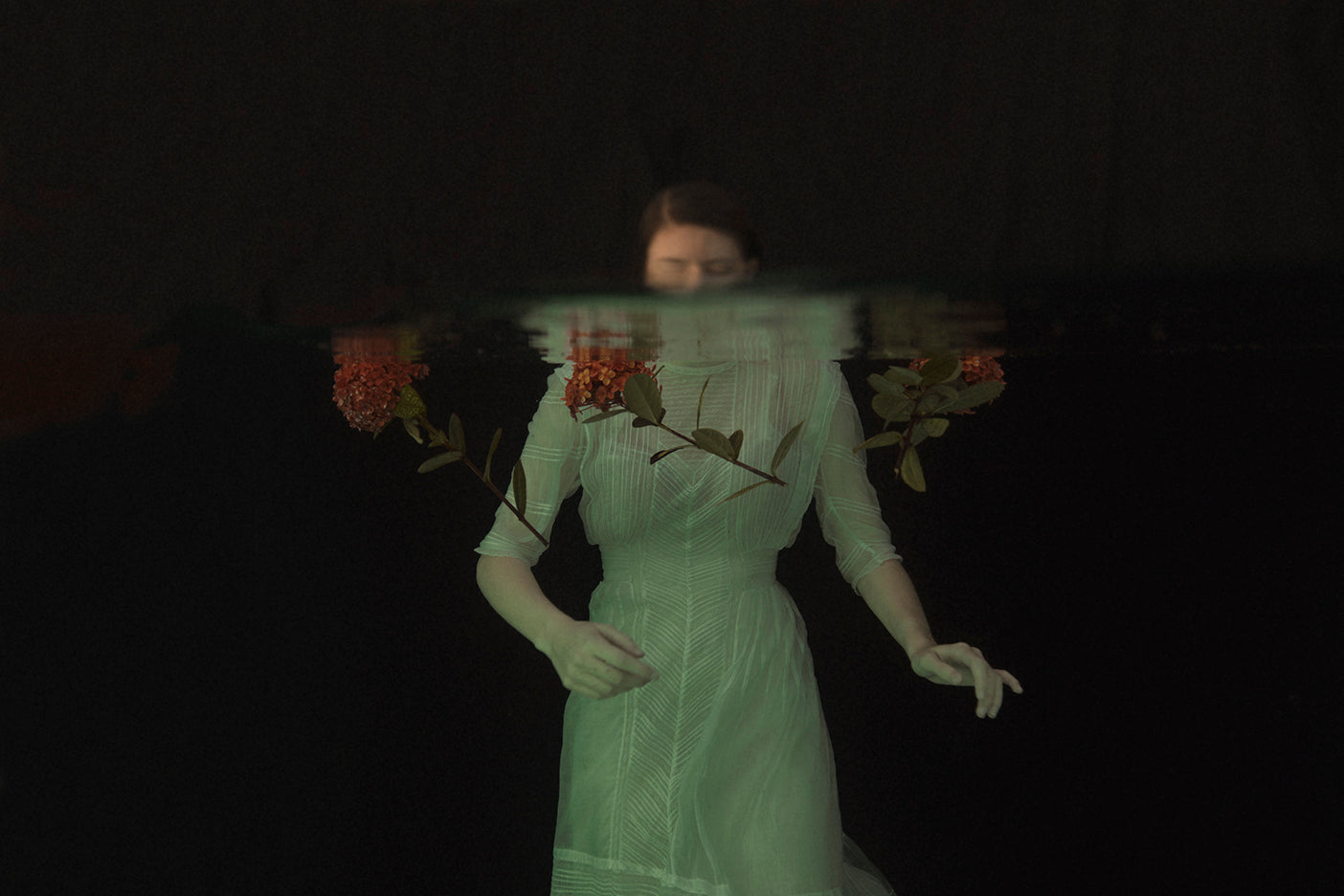 A whimsical photograph featuring a person in a green dress with floral elements, creating a mystical and ethereal ambiance.