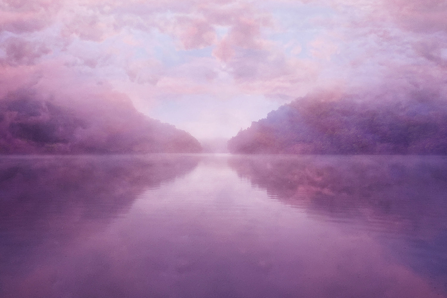 A serene landscape photograph featuring a body of water with a pink hue, possibly a lake or sea, surrounded by mountains or landmasses in the distance. The sky is also pink, creating a calm and dreamlike atmosphere.
